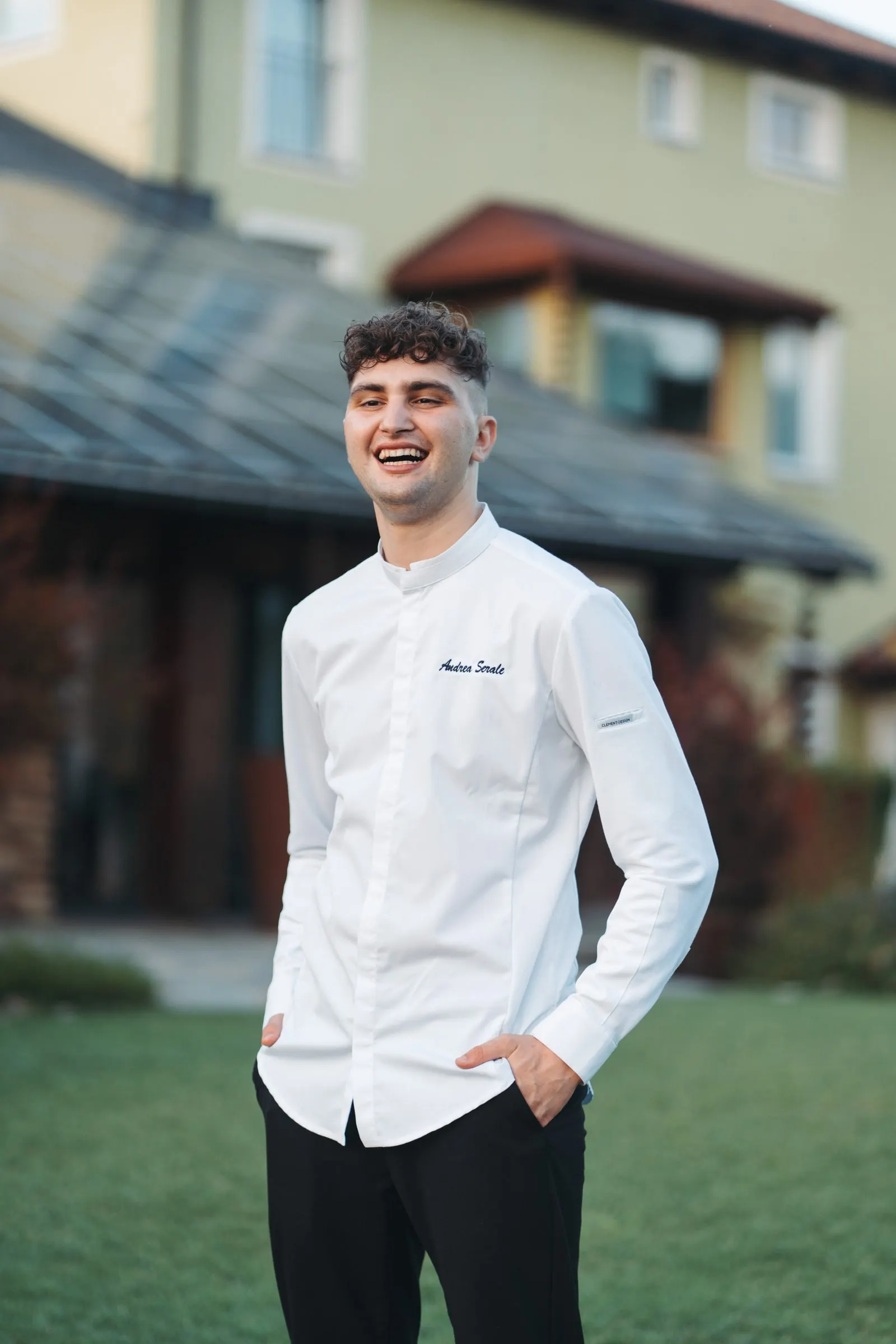 Andrea Serale sorride nel giardino di Villa San Lorenzo, in giacca da chef