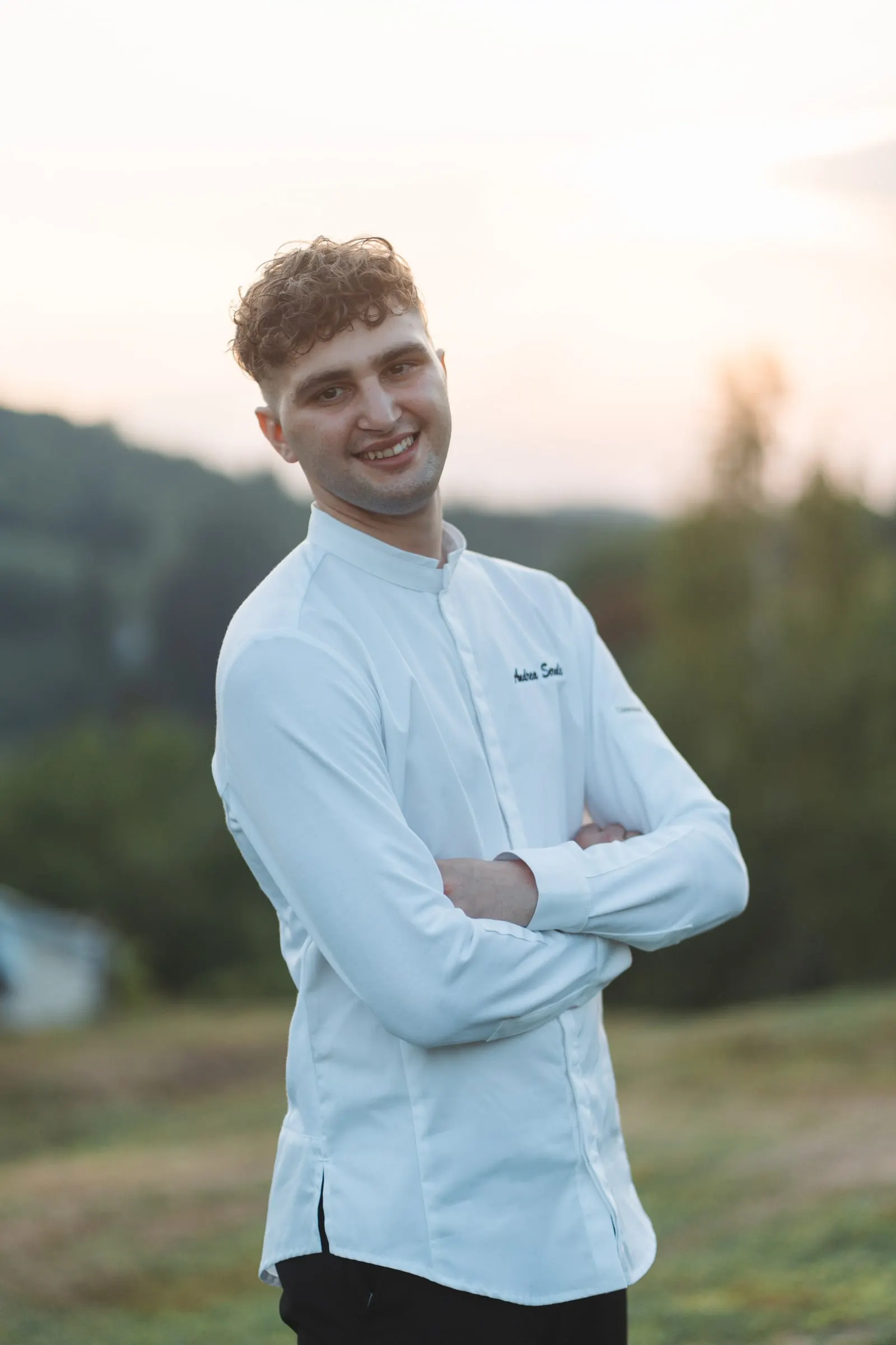 Andrea Serale in giacca da chef nel giardino di Villa San Lorenzo, al tramonto